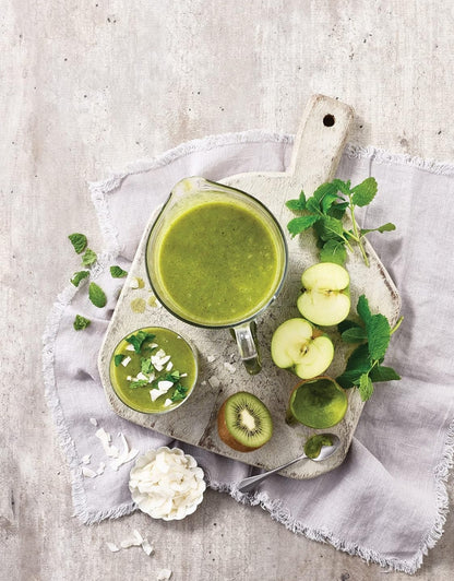 Green smoothie made using Kenwood 400W 2L juicer blender, served with kiwi, apple, and mint on a wooden board