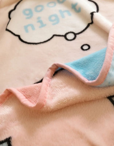 Close-up of plush fabric with "good night" text on kids blanket.
