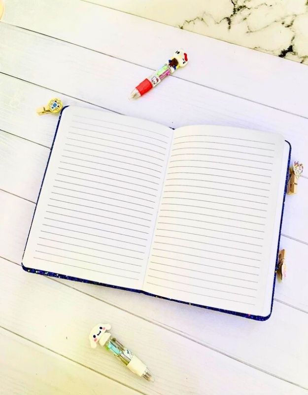 Open notebook with lined pages on a wooden surface