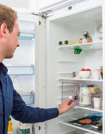 Man placing a transparent lockable storage box inside a refrigerator for food security.
