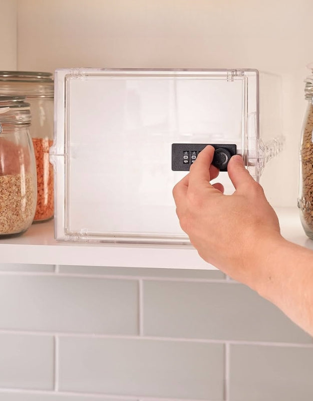 Person using a transparent lockable storage box with a combination lock placed on a kitchen shelf