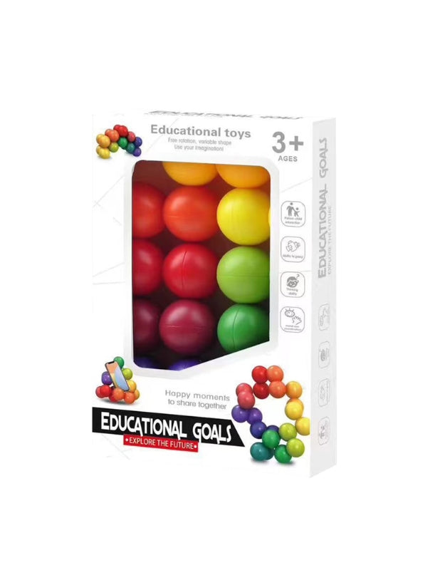 A close-up action shot of a hand connecting a red magnetic ball to a stick to build a structure.