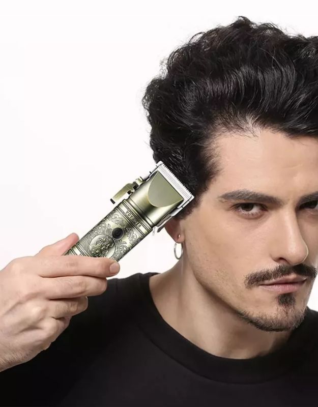 Man styling his hair with cordless voyager hair clipper and adjustable guard.