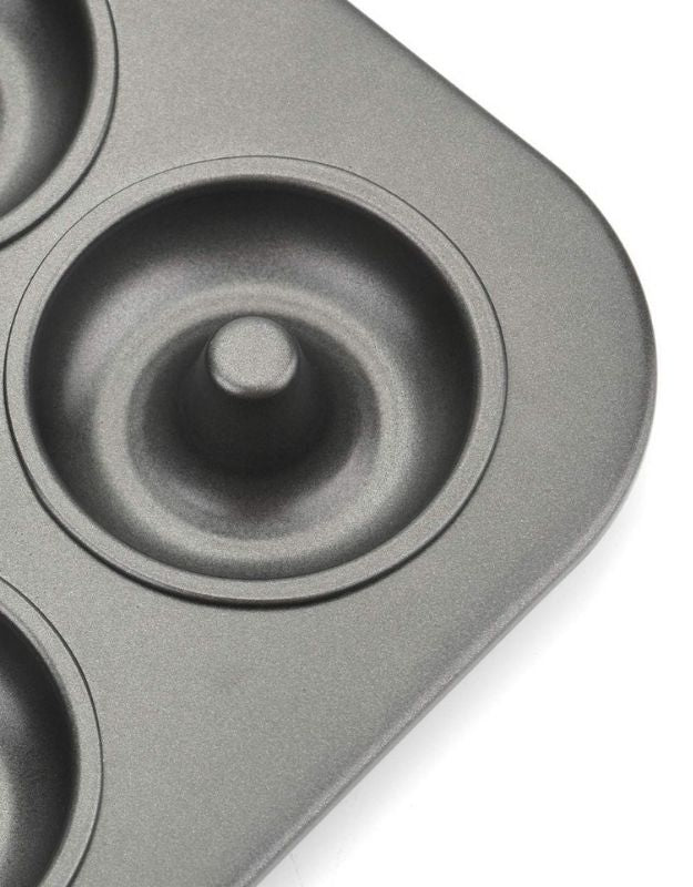 Gray donut-shaped baking mold on a white background. Close-up of nonstick mini donut pan cavity showing durable coating and smooth finish.