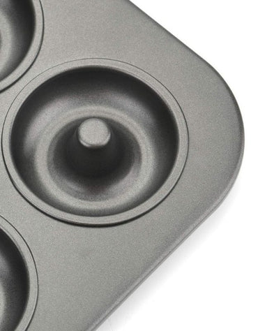 Gray donut-shaped baking mold on a white background. Close-up of nonstick mini donut pan cavity showing durable coating and smooth finish.