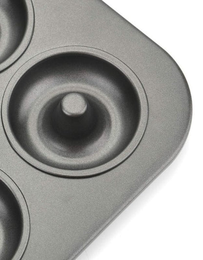 Gray donut-shaped baking mold on a white background. Close-up of nonstick mini donut pan cavity showing durable coating and smooth finish.