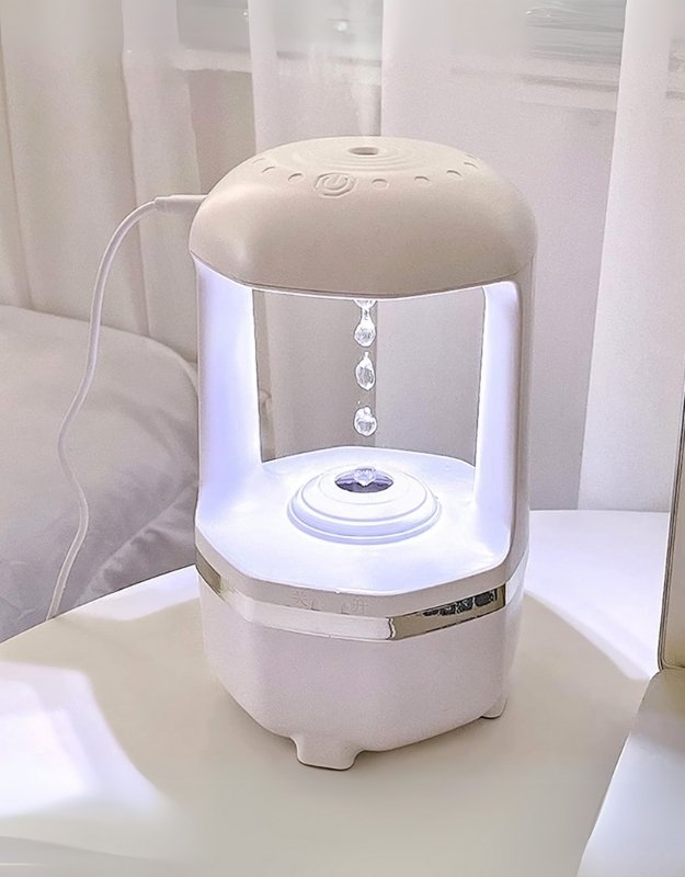 Humidifier with water droplet feature on a table. Modern humidifier with water droplet feature and soft LED glow.