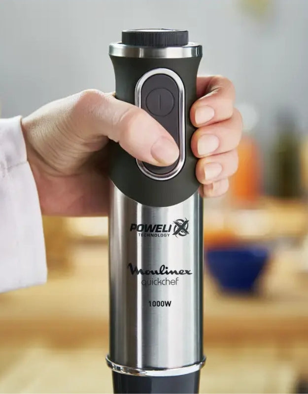 Close-up hand holding Moulinex QuickChef 1000W immersion blender handle with control buttons