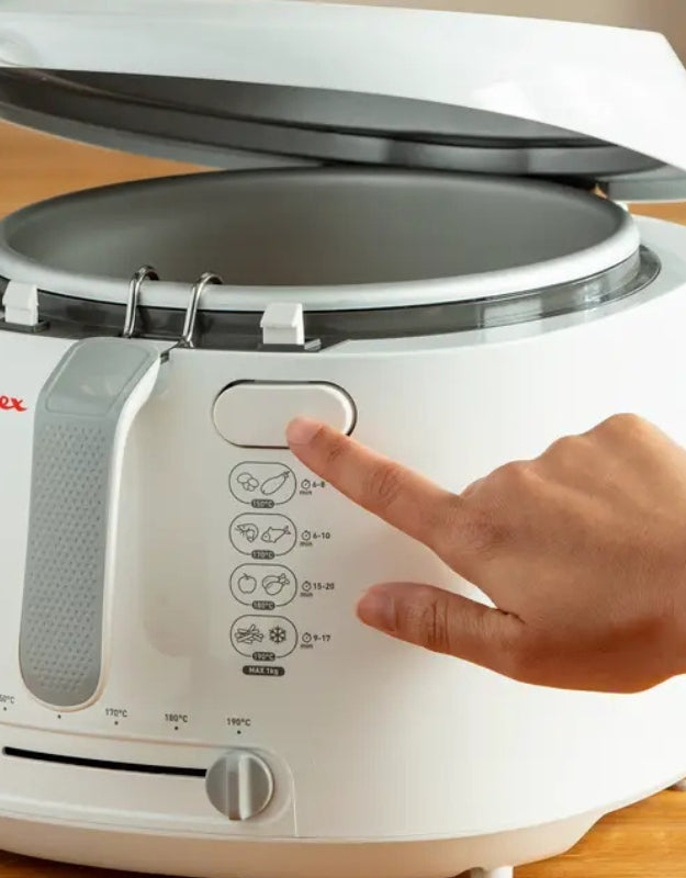 User pressing open button on Moulinex 1470W deep fryer for easy lid access