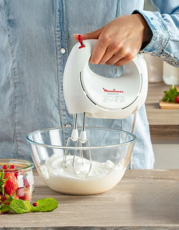 Moulinex Easy Max 200W hand mixer whipping cream in a glass bowl, ideal for baking and dessert preparation