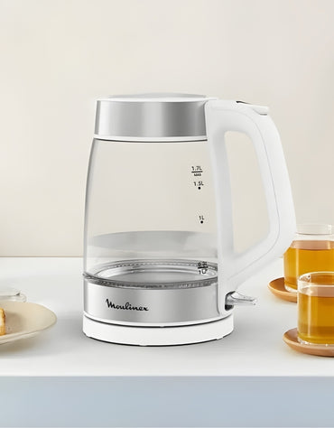 Moulinex 1.7L glass electric kettle placed on kitchen table beside tea cups – stainless steel base