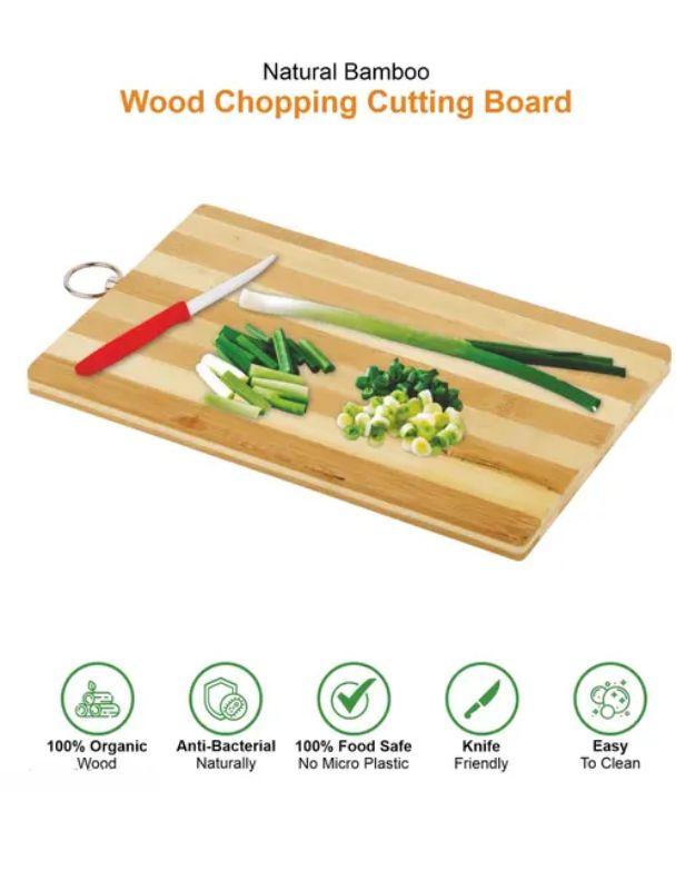 Bamboo cutting board with vegetables and knife on a white background. Natural bamboo chopping board with sliced green onions and icons highlighting food safety and eco-friendly features.
