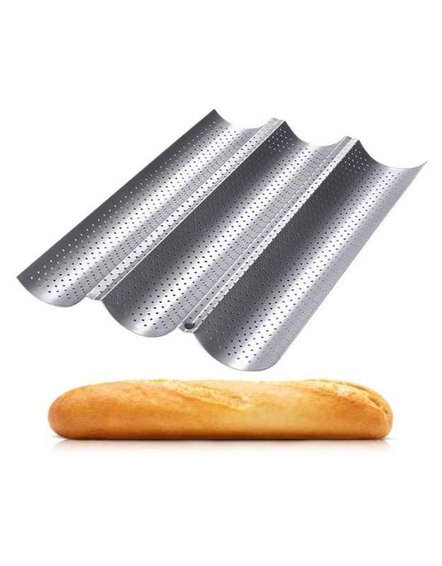 Bread baking pans with a loaf of bread on a white background. Nonstick perforated baguette baking tray for homemade French bread.