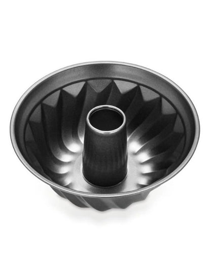 Metal bundt cake pan on a white background. Non-stick fluted Bundt cake pan with central tube for even baking.
