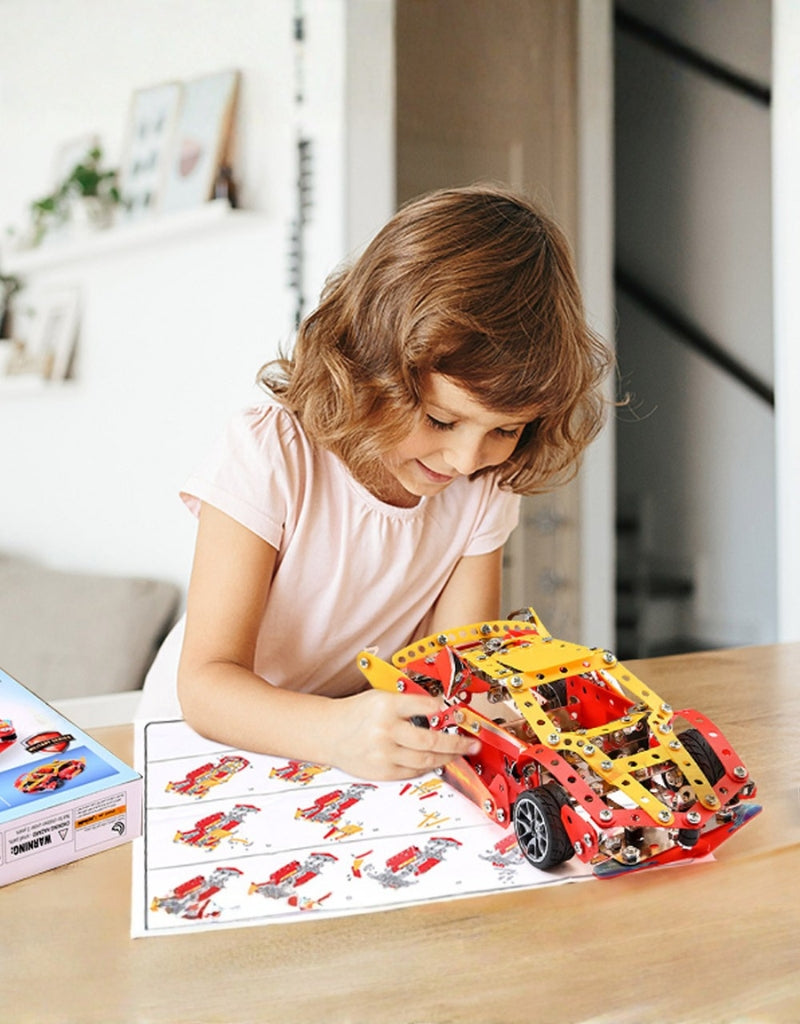 Young girl happily playing with and assembling the HotWheel 370 PCS metal car building kit.