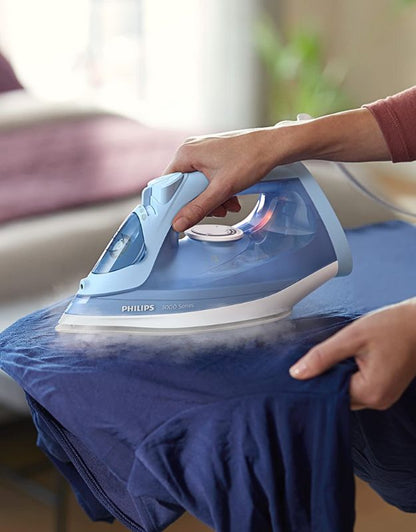 Philips steam iron in use while ironing a blue shirt.