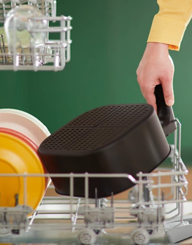 Philips airfryer non-stick basket being placed in dishwasher.