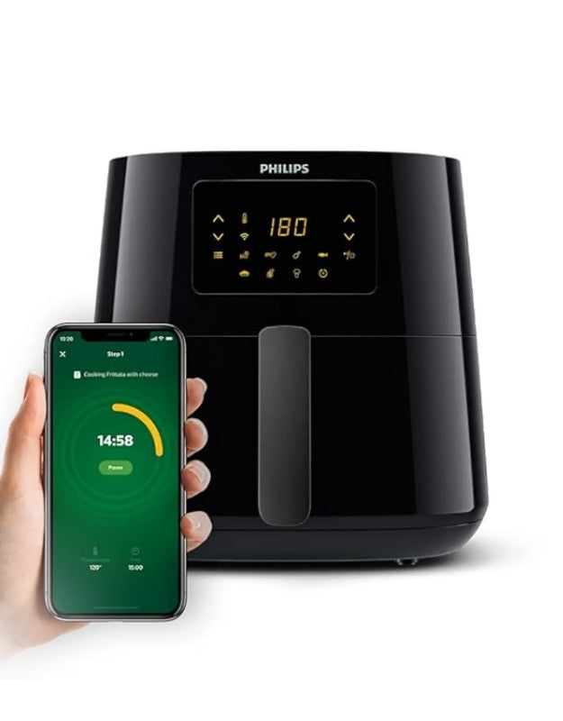 A Philips XL size 6.2 liter airfryer with a digital display and a smartphone showing the Philips app connected to the device.