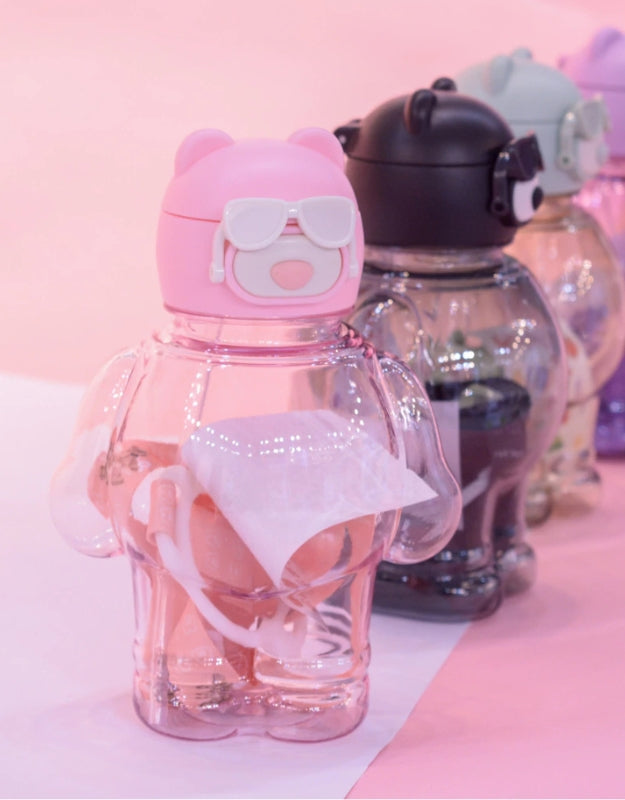 Pink bear-shaped water bottle displayed in front of other bear bottles in a row, 850ml.