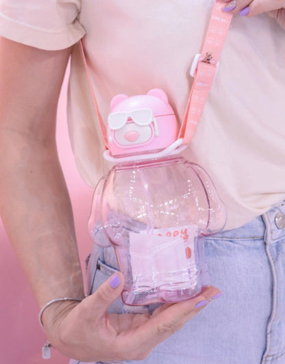 Model wearing pink bear-shaped water bottle with white sunglasses and pink strap, 850ml.