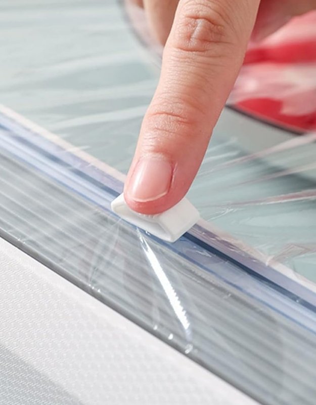 Person applying clear adhesive strip to a surface