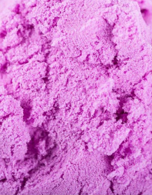 A detailed, close-up shot showing the unique, granular texture of vibrant purple play sand