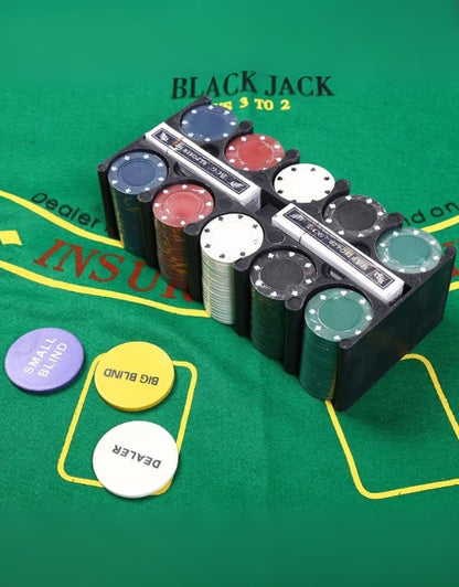 The poker set's chip rack, filled with chips and playing cards, sitting on the green felt playing mat