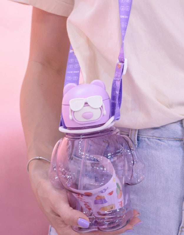 Model holding purple bear-shaped water bottle with white sunglasses and purple strap, 850ml.