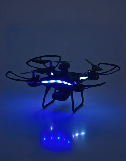 Quadcopter drone flying at night with blue LED lights