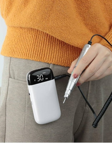 Rechargeable nail drill clipped to pocket for portable use.