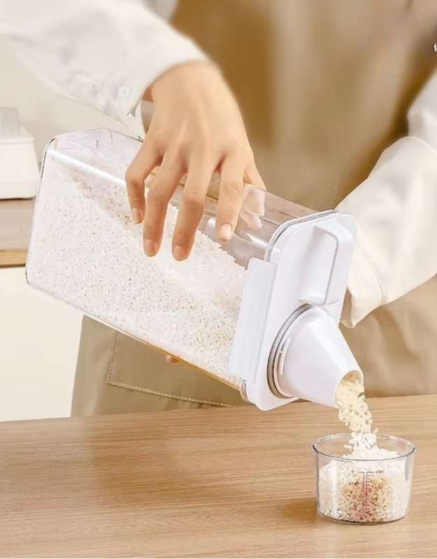 Person using a rice measuring cup to pour rice into a glass container. Airtight rice storage container pouring rice into measuring cup.