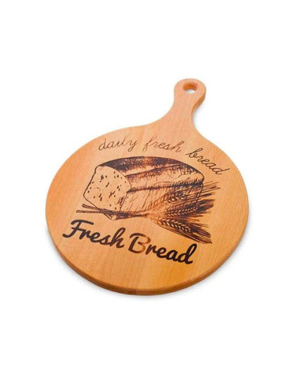 Wooden cutting board with bread design and text on a white background.
Round wooden breadboard with handle and “Fresh Bread” engraving on white background.