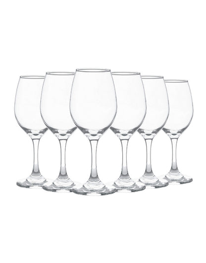 Set of six clear wine glasses on a white background. Set of six clear empty wine glasses with tall stems, arranged in a row on white background.