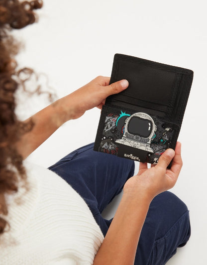 Child holding closed Smiggle Astronaut Black Wallet with 3D astronaut detail