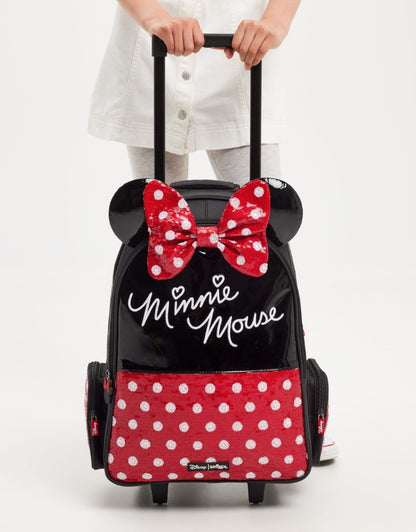 Child holding Smiggle Minnie Mouse trolley backpack with red polka-dot bow and ears