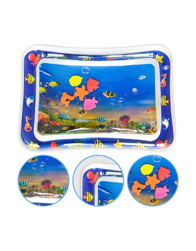 A smiling baby in a white shirt reaching down and playing with the colorful, floating toys inside the water-filled tummy time mat