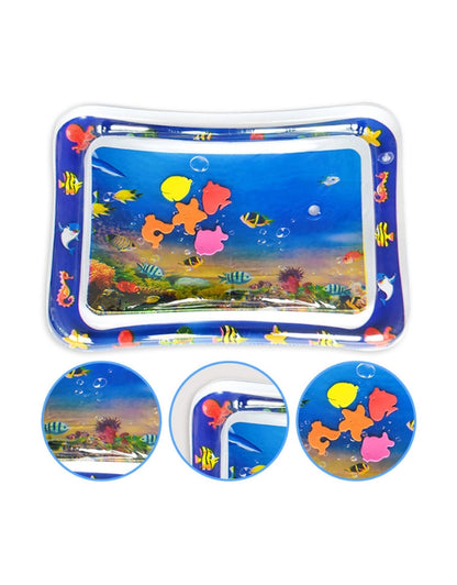 A smiling baby in a white shirt reaching down and playing with the colorful, floating toys inside the water-filled tummy time mat