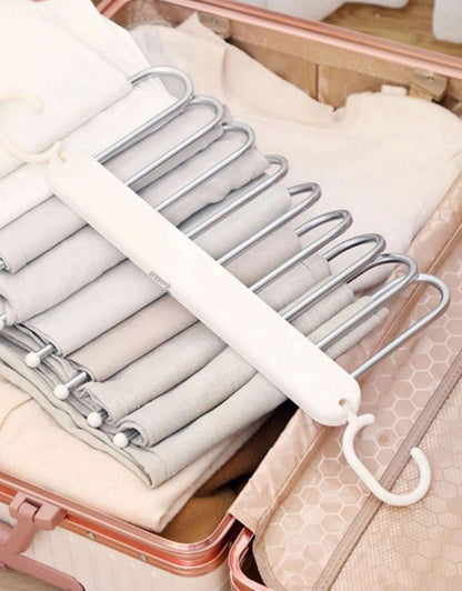 Space-saving pants hanger placed inside suitcase for travel organization.
