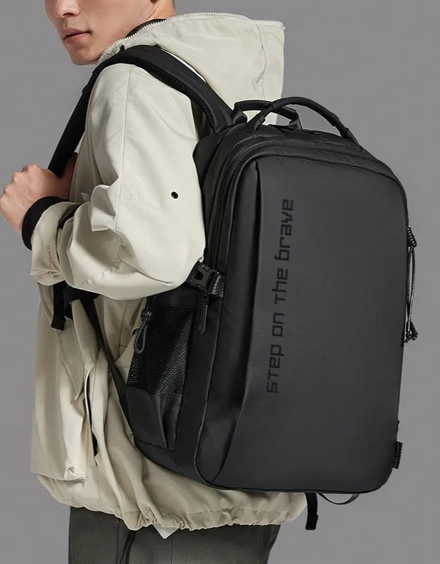Model wearing black Step On The Brave waterproof outdoor backpack.