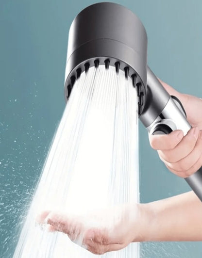 Shower head with water flowing against a neutral background. Filtered shower head with strong water flow demonstrated on hand.