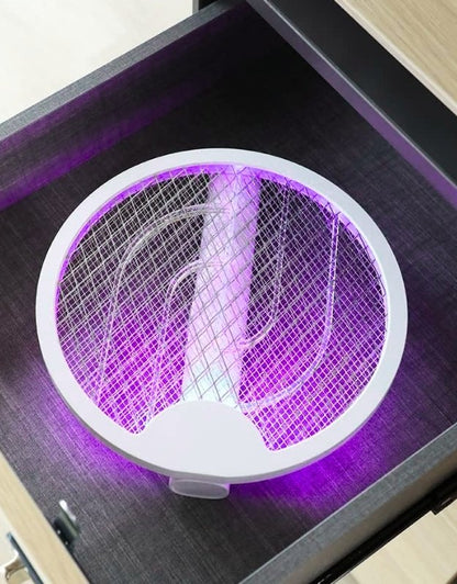 Electronic insect killer with purple light on a table.