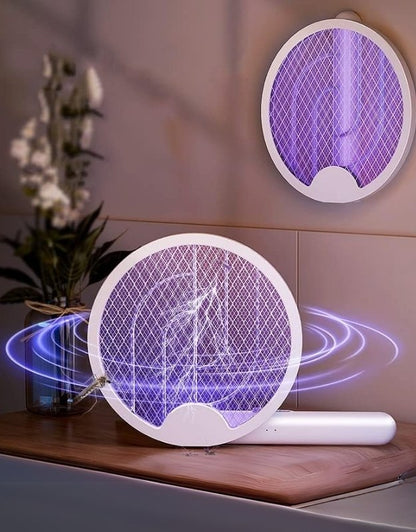 Electric fly swatter with purple mesh on a wooden surface.