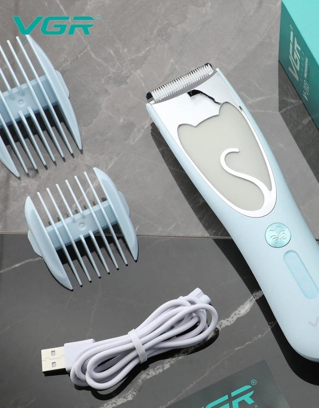Hair trimmer with attachments and USB cable on a marble surface. VGR V-203 pet grooming clipper with guide combs and USB charging cable.
