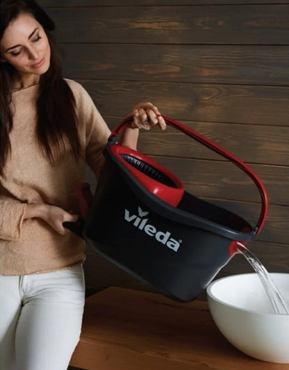Vileda Turbo mop bucket with handle pouring dirty water out.