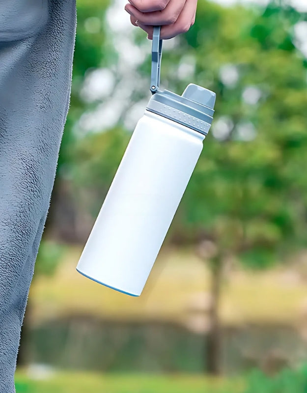 Person holding white stainless steel vacuum water bottle 750ml outdoors