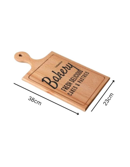 Wooden bread board with 'Bakery' engraving and measurements on a white background. Wooden bakery cutting board with handle, size 38x23 cm.