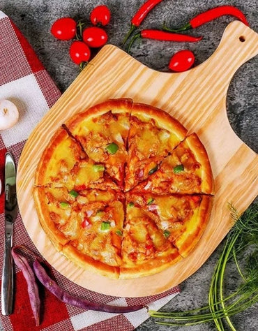 Pizza on a wooden board with cherry tomatoes and red peppers on a checkered cloth. Wooden pizza peel serving a cheese pizza, styled with fresh vegetables and chili peppers.