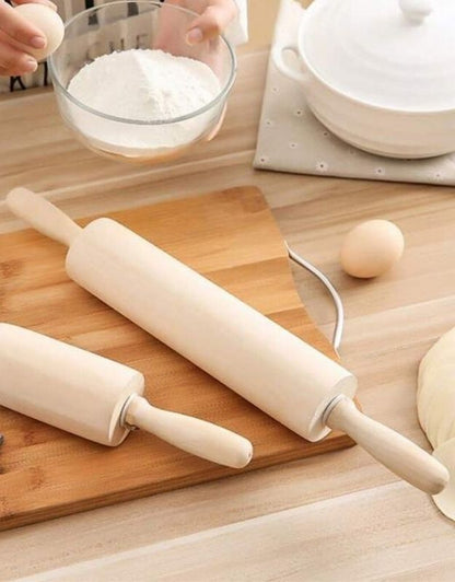 Two rolling pins on a wooden board with flour and eggs in the background. Wooden rolling pin on kitchen table with flour and eggs, perfect for baking and dough rolling.